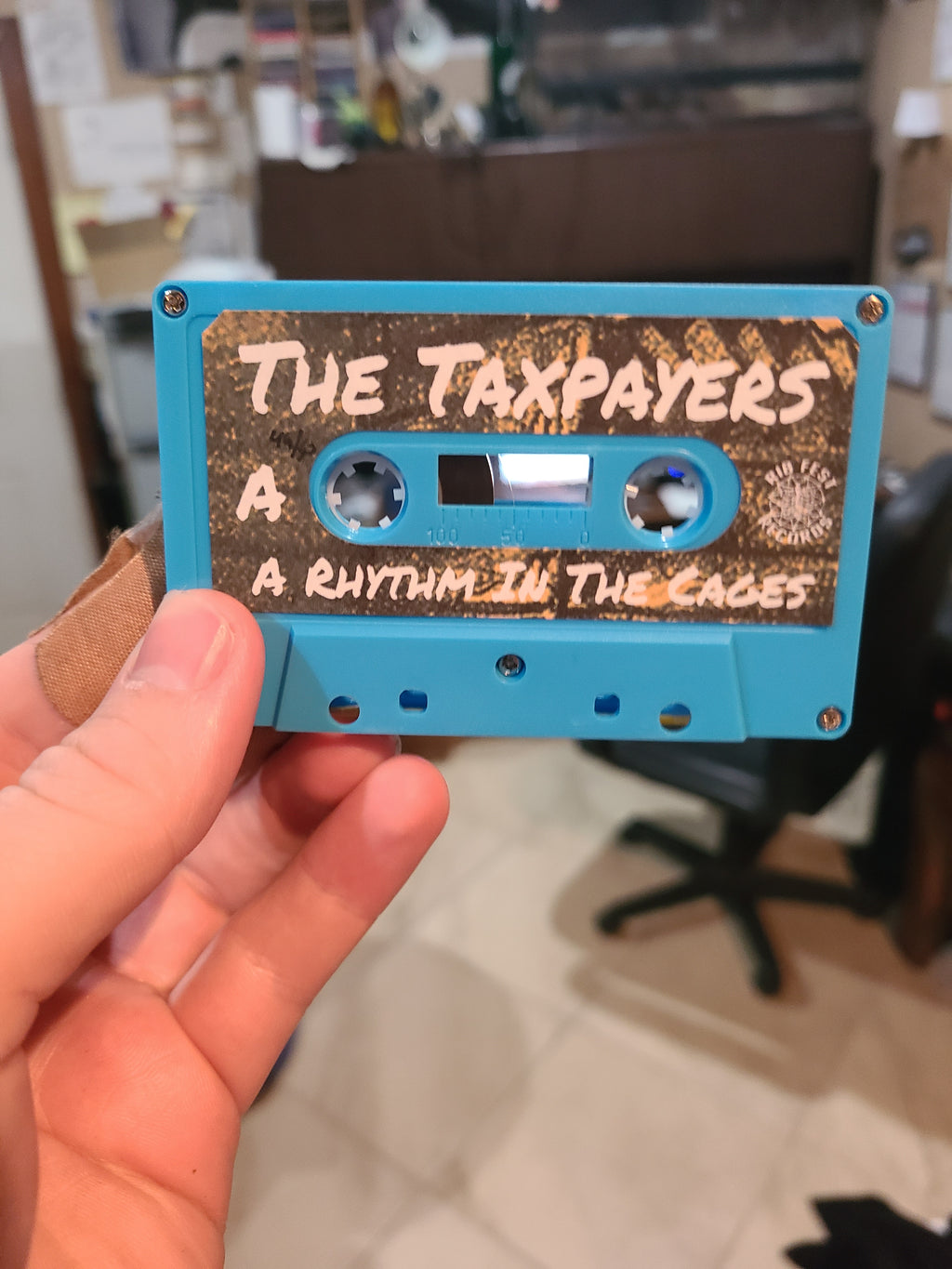 The Taxpayers - A Rhythm In The Cages - Cassette Tape Physical Media