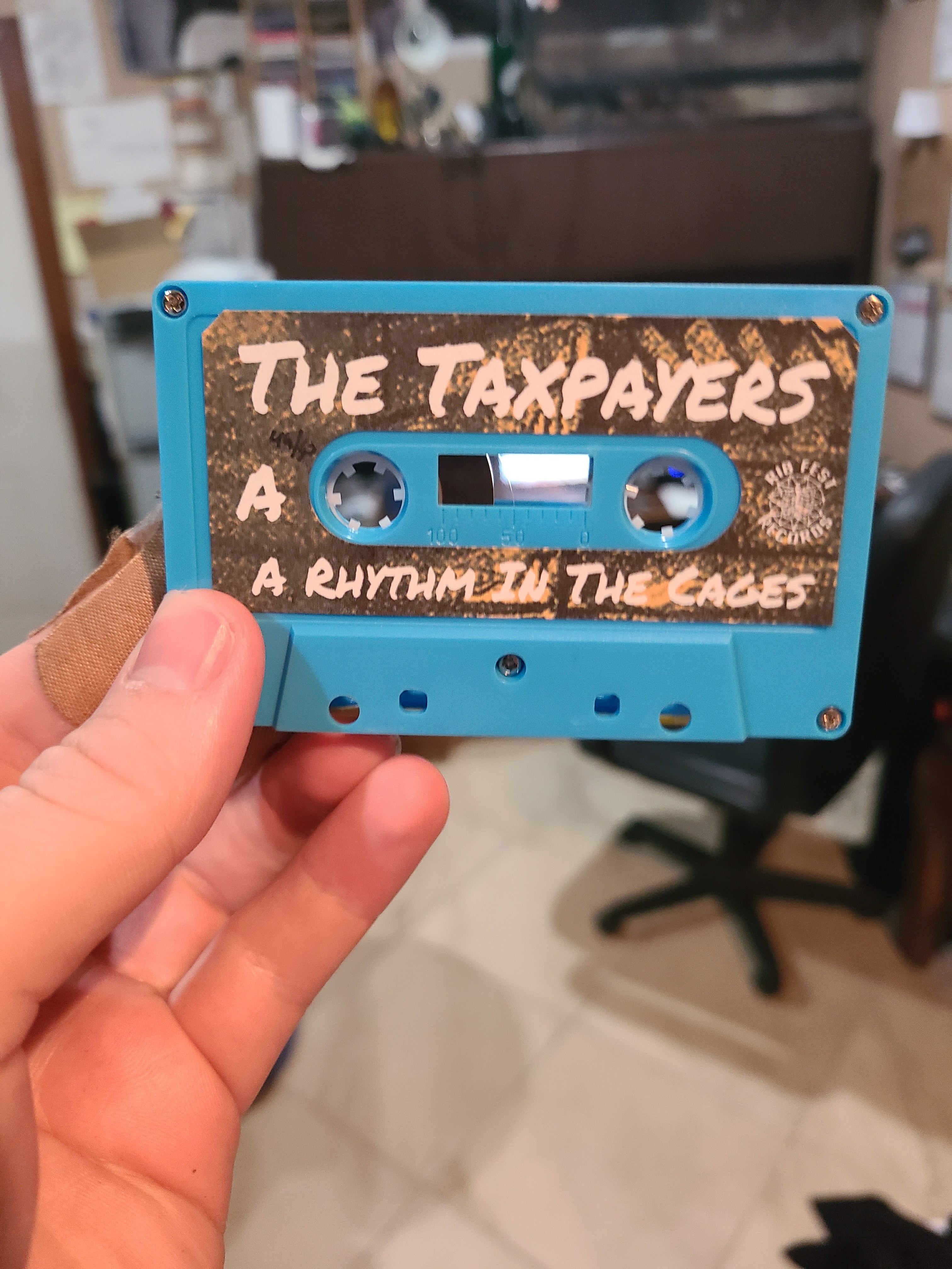 The Taxpayers - A Rhythm In The Cages - Cassette Tape Physical Media
